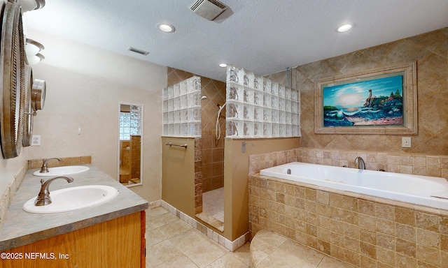 bathroom featuring tile patterned floors, vanity, a textured ceiling, and independent shower and bath