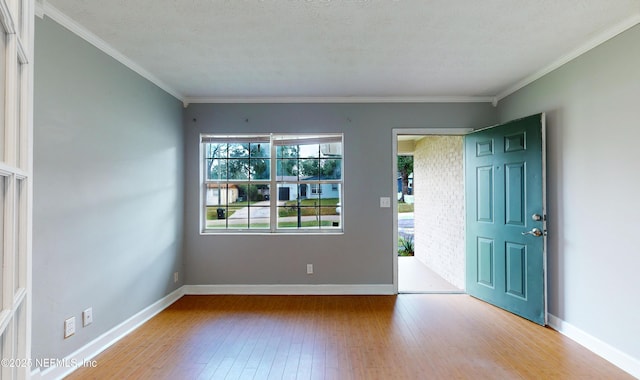 entryway with a textured ceiling, light hardwood / wood-style floors, and crown molding