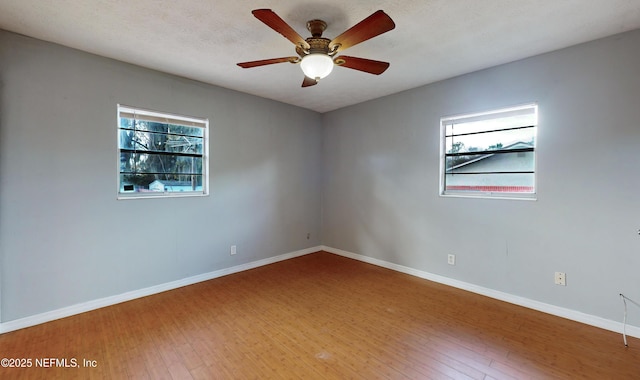 spare room featuring ceiling fan, plenty of natural light, and hardwood / wood-style flooring