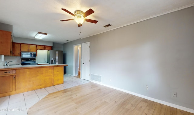 kitchen with ceiling fan, sink, stainless steel appliances, backsplash, and kitchen peninsula