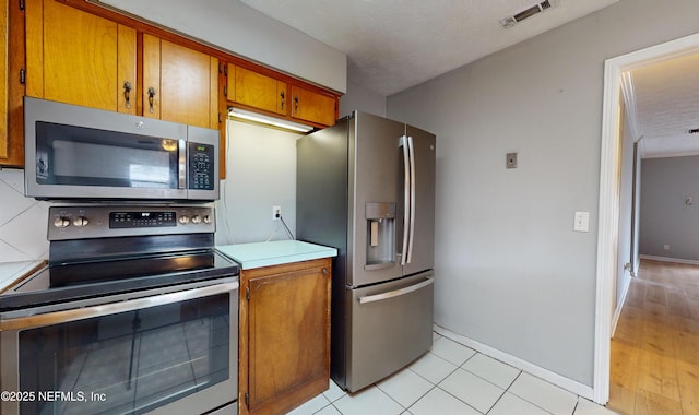 kitchen with light tile patterned flooring and appliances with stainless steel finishes