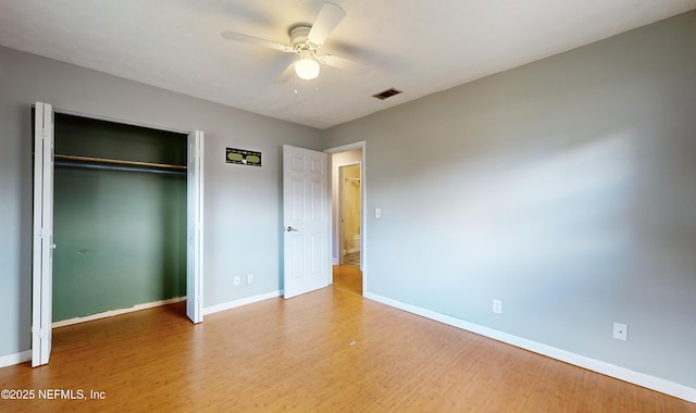 unfurnished bedroom with hardwood / wood-style flooring, ceiling fan, and a closet