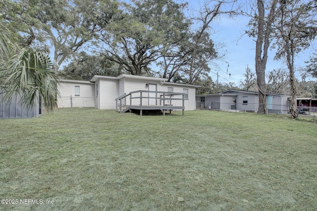 rear view of property with a lawn and a wooden deck