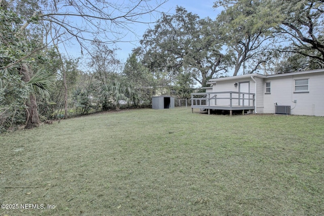 view of yard with a shed, central air condition unit, and a wooden deck