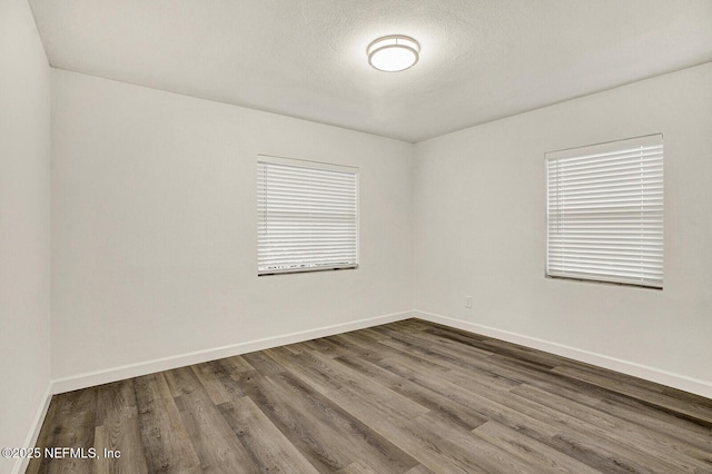 unfurnished room with hardwood / wood-style floors and a textured ceiling