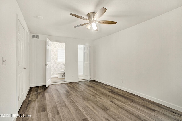 unfurnished bedroom featuring connected bathroom, ceiling fan, and hardwood / wood-style flooring