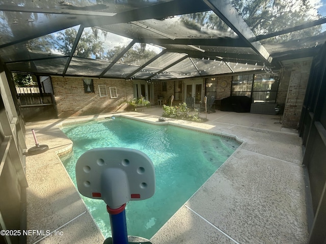 view of swimming pool featuring a lanai and a patio area