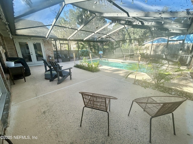 view of swimming pool featuring a lanai, a patio, and french doors