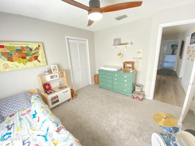 bedroom with carpet flooring, ceiling fan, a textured ceiling, and a closet