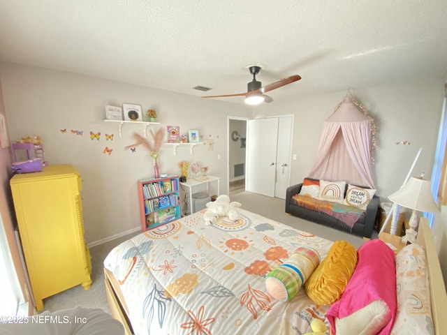 bedroom with a textured ceiling, carpet floors, and ceiling fan