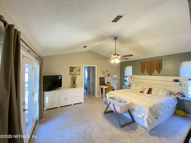 carpeted bedroom with a textured ceiling, vaulted ceiling, and ceiling fan