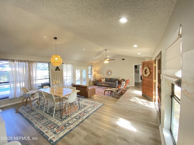 dining space featuring ceiling fan, french doors, a textured ceiling, lofted ceiling, and hardwood / wood-style flooring