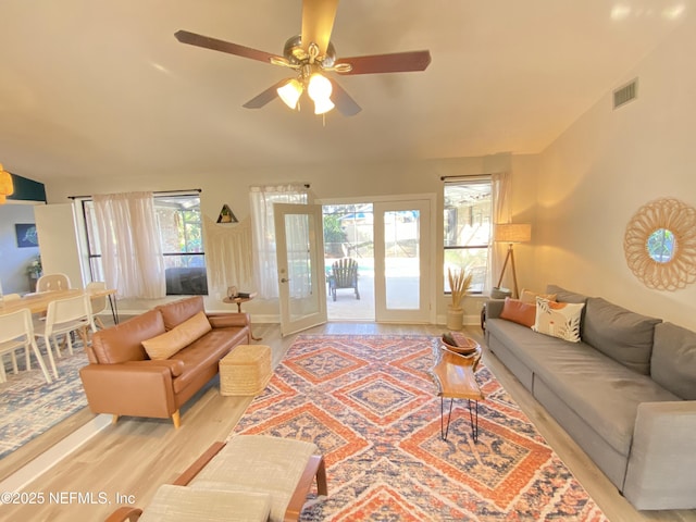 living room with ceiling fan, a healthy amount of sunlight, and light wood-type flooring