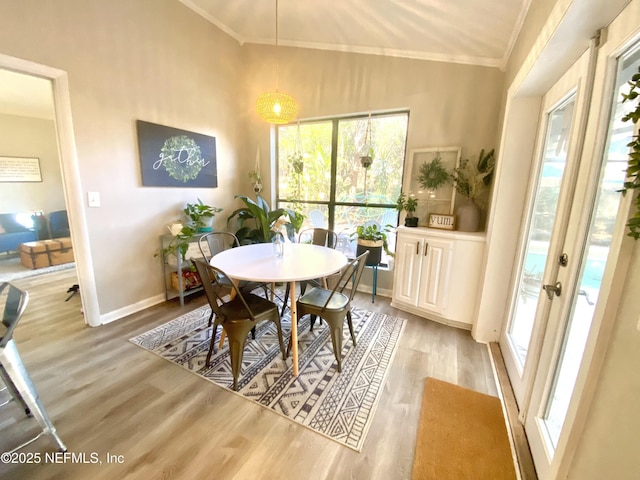 dining space with light hardwood / wood-style floors and ornamental molding