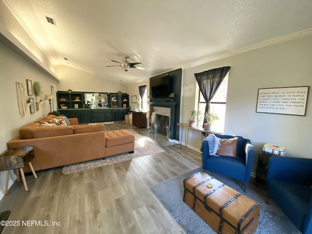 living room with hardwood / wood-style floors, a textured ceiling, ceiling fan, and ornamental molding