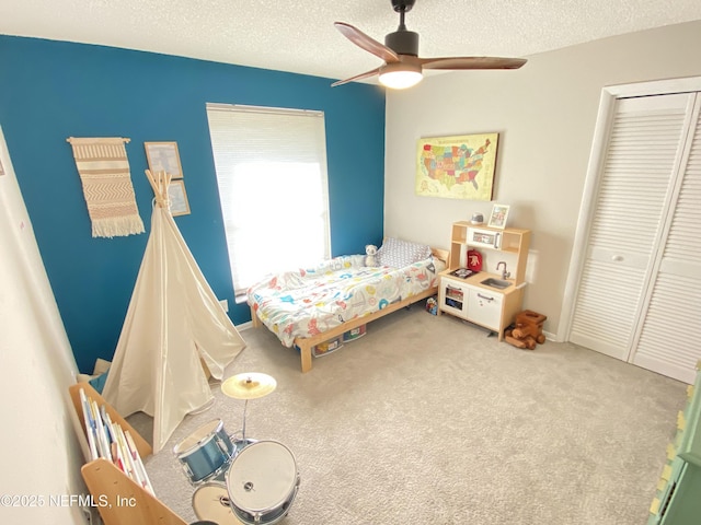 bedroom featuring carpet flooring, ceiling fan, a textured ceiling, and a closet