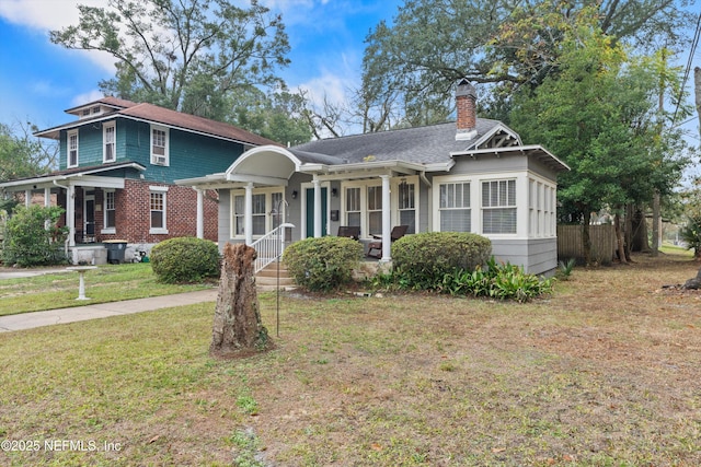 view of front of house featuring a front lawn and covered porch