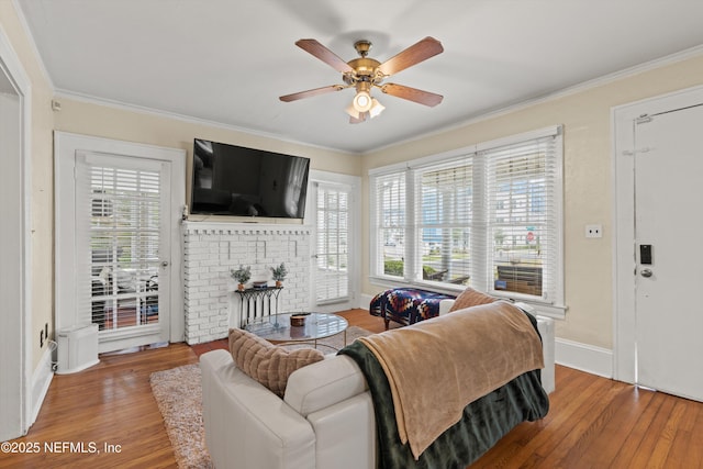 living room featuring wood-type flooring, plenty of natural light, crown molding, and ceiling fan