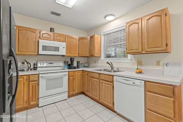 kitchen with white appliances, sink, and light tile patterned floors