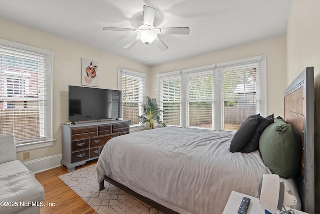 bedroom featuring multiple windows, ceiling fan, and light hardwood / wood-style floors