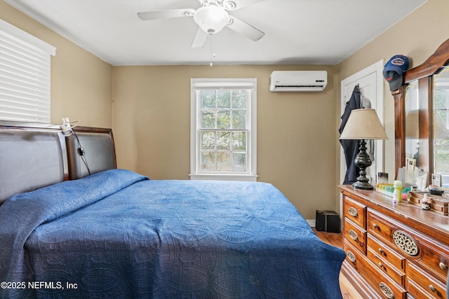 bedroom with hardwood / wood-style flooring, a wall mounted AC, and ceiling fan