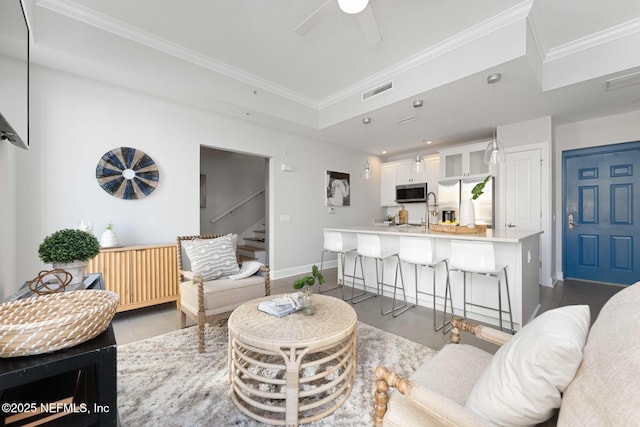 living room featuring ceiling fan, light tile patterned flooring, crown molding, and sink