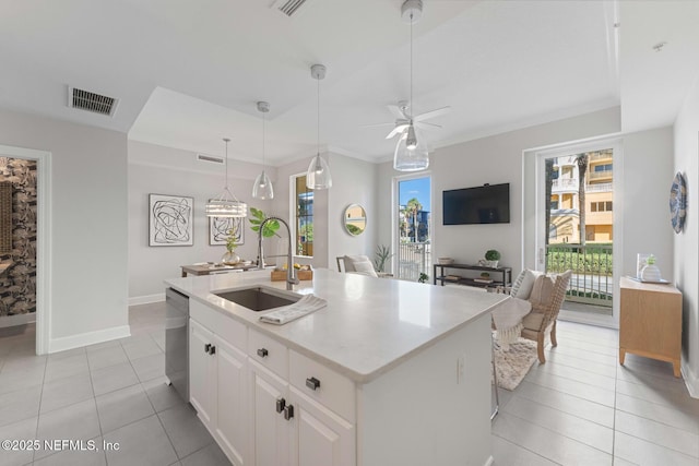 kitchen featuring a center island with sink, white cabinets, sink, stainless steel dishwasher, and ceiling fan