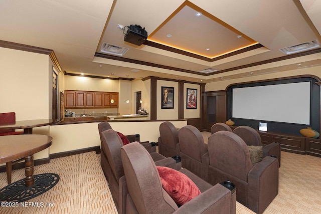 cinema with light colored carpet, a raised ceiling, and crown molding