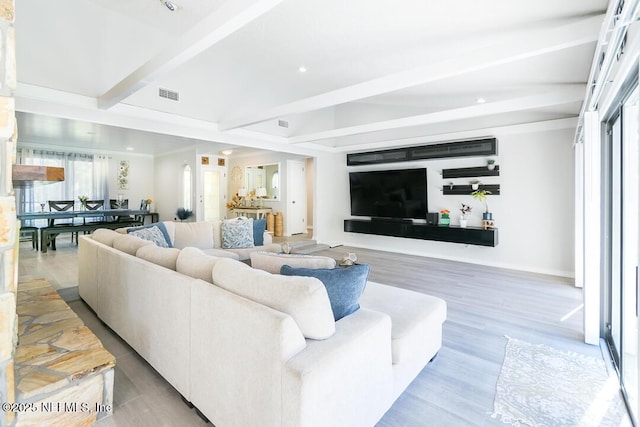 living room featuring beam ceiling and light hardwood / wood-style floors