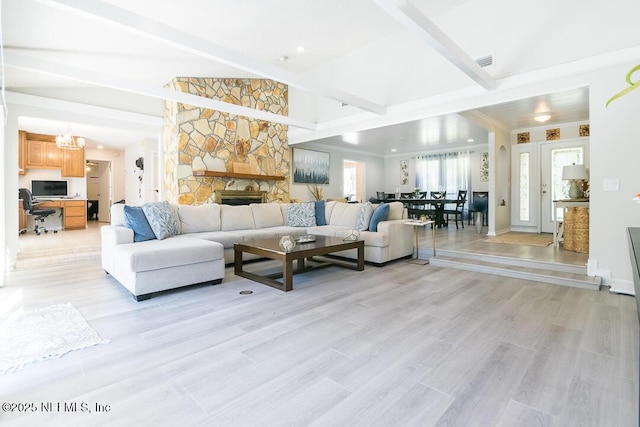 living room with beam ceiling, a fireplace, and light wood-type flooring