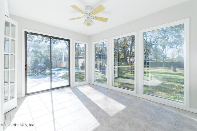 unfurnished sunroom with ceiling fan