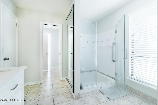 bathroom with tile patterned floors, a shower with door, and vanity