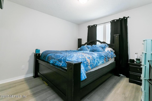 bedroom featuring hardwood / wood-style flooring and a textured ceiling