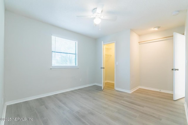 unfurnished bedroom with ceiling fan, light wood-type flooring, and a closet