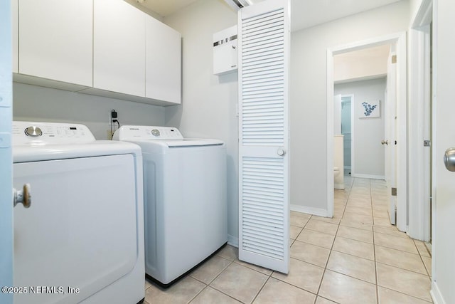 laundry room with cabinets, light tile patterned flooring, and washing machine and dryer