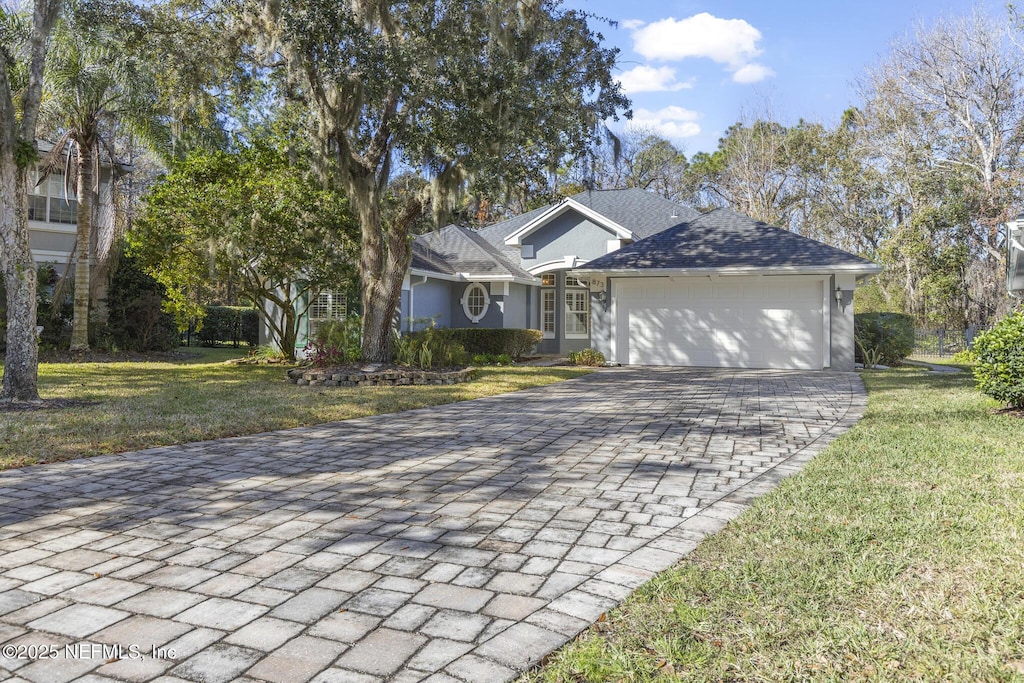 view of front of property featuring a front lawn and a garage