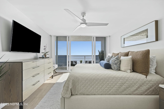 bedroom with access to outside, light hardwood / wood-style flooring, expansive windows, and ceiling fan