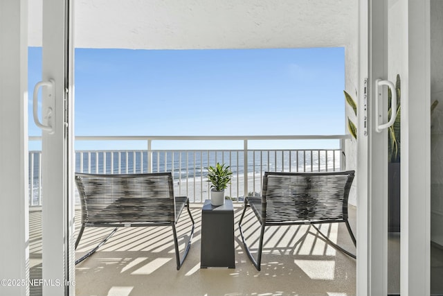 balcony with a water view and a beach view