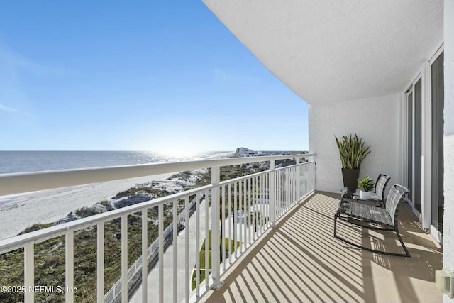 balcony featuring a water view and a view of the beach