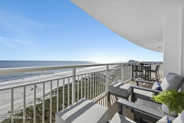 balcony featuring a beach view and a water view