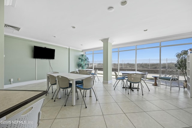 dining area featuring a wall of windows, a wealth of natural light, light tile patterned flooring, and ornamental molding