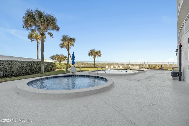 view of swimming pool featuring a jacuzzi