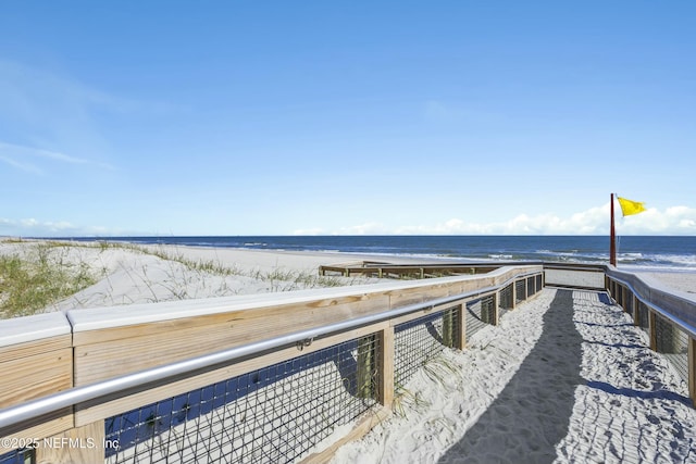 dock area with a water view and a beach view