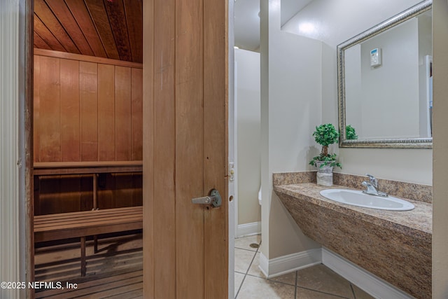 bathroom featuring tile patterned floors, sink, and wooden ceiling