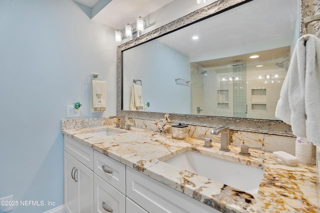 bathroom featuring a shower with door and vanity