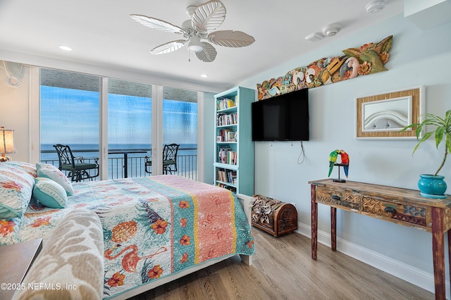 bedroom with ceiling fan, wood-type flooring, and access to exterior