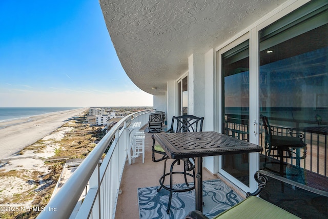 balcony featuring a water view and a view of the beach