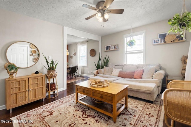 living room featuring ceiling fan, a textured ceiling, and a wealth of natural light