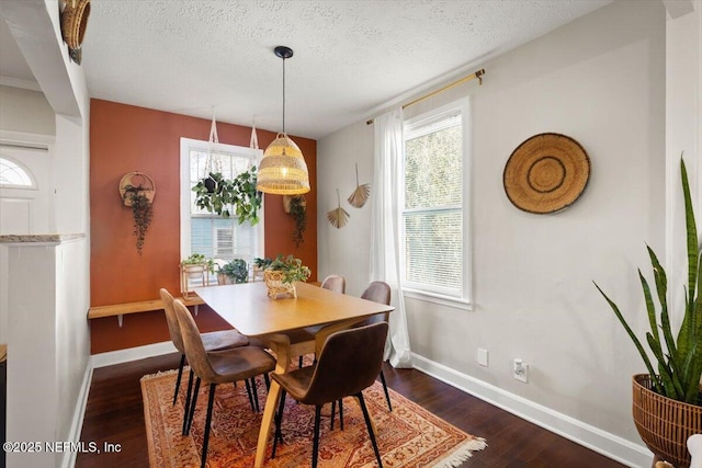 dining area with dark wood-type flooring and a textured ceiling