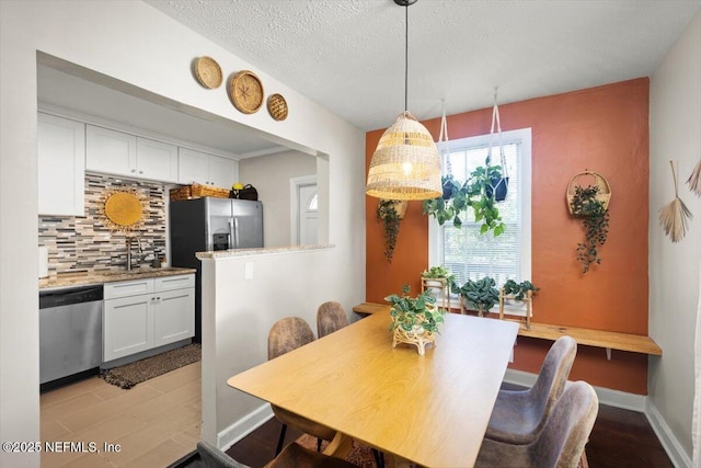 dining room with a textured ceiling and sink